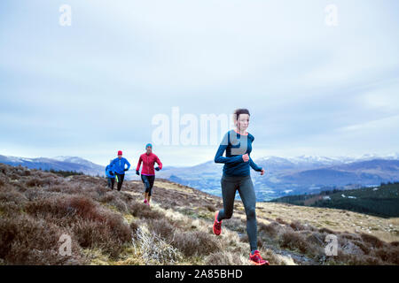 Freunde joggen auf dem Weg in die Berge Stockfoto