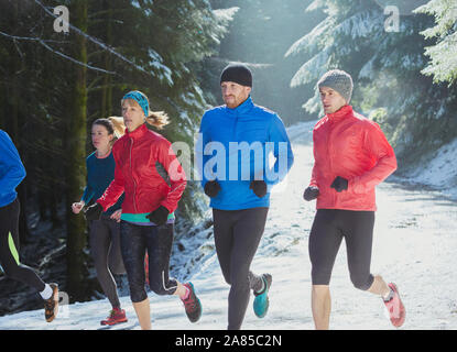 Freunde Joggen im verschneiten Wald Stockfoto