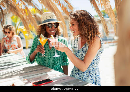 Glückliche junge Frauen Freunde trinken Cocktails auf Sunny Beach Bar Stockfoto