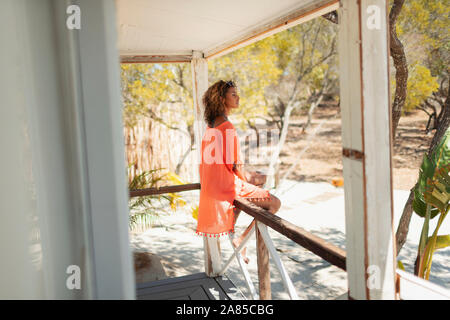 Ruhige junge Frau am Strand Hütte Terrasse Stockfoto