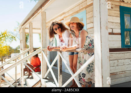 Mutter und erwachsene Tochter entspannt auf Sunny beach Hütte Terrasse Stockfoto