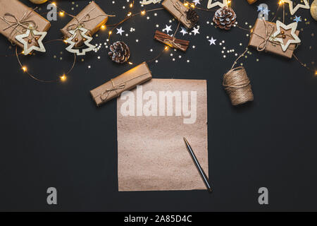 Frohes Neues Jahr 2020. Schreiben Ziele auf Kraftpapier mit Weihnachten Gold und Silber Dekorationen auf schwarzen Hintergrund eingerichtet. Winter, neues Jahr. Stockfoto