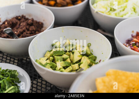 Tortilla Eintauchen in zertrümmert, Avocado, grüne Guacamole dip Stockfoto