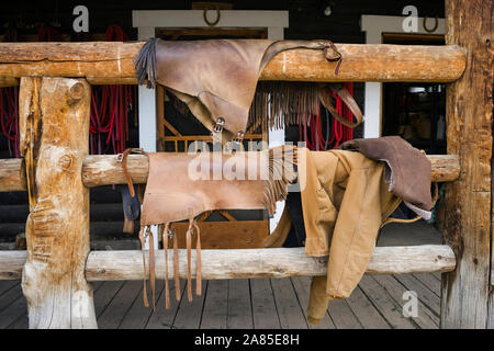 Leder Chaps hängen auf einer hölzernen Veranda Geländer nach Reiten Stockfoto