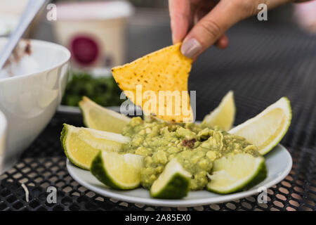 Tortilla Eintauchen in zertrümmert, Avocado, grüne Guacamole dip Stockfoto