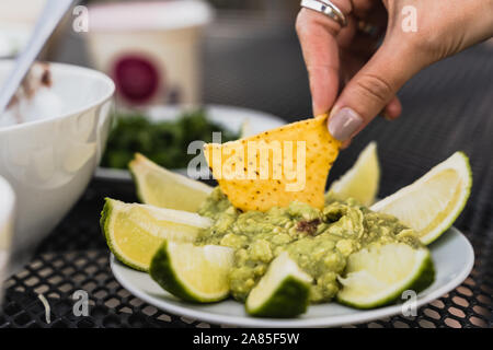 Tortilla Eintauchen in zertrümmert, Avocado, grüne Guacamole dip Stockfoto