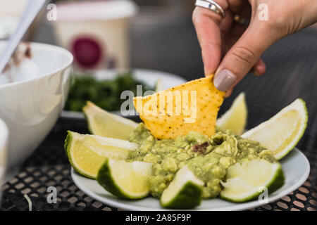 Tortilla Eintauchen in zertrümmert, Avocado, grüne Guacamole dip Stockfoto