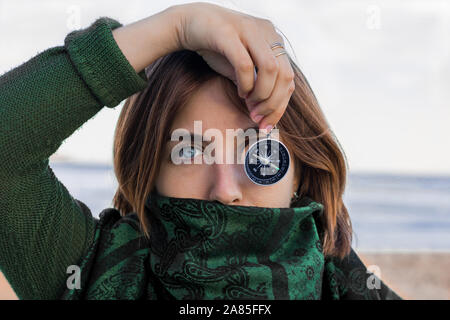 Porträt einer jungen Frau mit blauen Augen. Sie hält eine Kompass Stockfoto