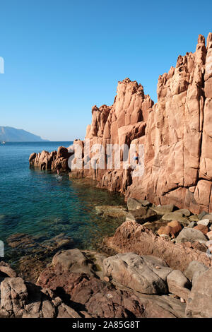 Touristen entdecken das Rocce Rosse/Porphyr Red Rocks Beach auf der Sardinien Küste bei Arbatax Tortolì, Ogliastra Küste, Sardinien, Italien Stockfoto