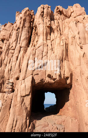 Das quadratische Loch schneiden durch den Rocce Rosse/Porphyr Red Rocks Beach Bildung, Sardinien Küste, Arbatax, Küste in Tortolì Ogliastra, Sardinien, Italien Stockfoto