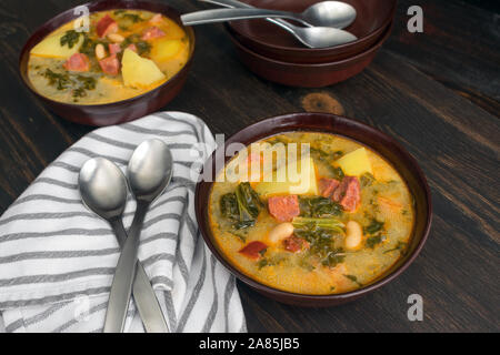 Portugiesische Caldo Verde Suppe: Schalen mit traditionellen portugiesischen Wurst, Kartoffeln und Kohl Suppe auf einem dunklen Hintergrund Stockfoto