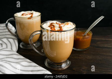 Caramel Brûlée Kaffee im Glas Becher: Kaffee mit Milch garniert mit Sahne und Karamell Sauce Stockfoto