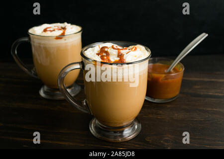 Caramel Brûlée Kaffee im Glas Becher: Kaffee mit Milch garniert mit Sahne und Karamell Sauce Stockfoto