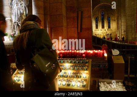 Frau Beleuchtung Kerzen in der Sacre coeur Paris Frankreich Stockfoto