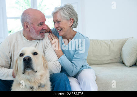 Älteres Ehepaar auf dem Sofa sitzen mit ihrem Hund Stockfoto