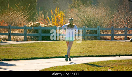 Eine Frau Laufen oder Joggen entlang eines Flusses Pfad in der Alten Mühle Abschnitt von Bend, Oregon Stockfoto