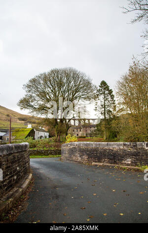 Eine Brücke über den Fluss Dee an Cowgill, Dentdale, North Yorkshire, Großbritannien mit Arten Gill Viadukt in der Ferne Stockfoto