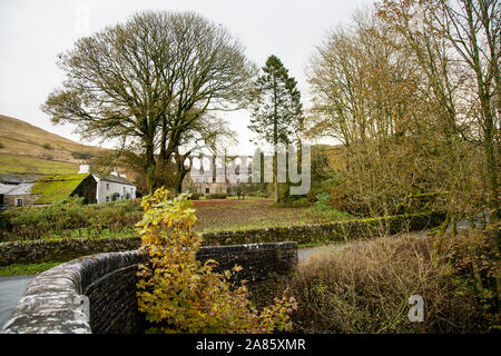 Eine Brücke über den Fluss Dee an Cowgill, Dentdale, North Yorkshire, Großbritannien mit Arten Gill Viadukt in der Ferne Stockfoto