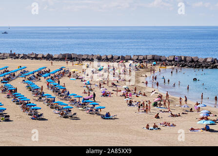 Teneriffa, Spanien - Oktober 13, 2019: Urlauber Menschen Sonnenbaden am Sandstrand von Playa de Los Cristianos, genießen Sie warmen Atlantischen Meer Teneriffa Stockfoto
