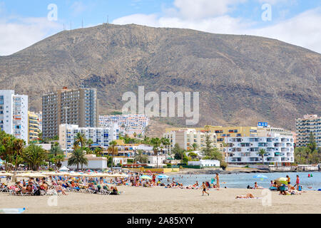 Teneriffa, Spanien - Oktober 13, 2019: die Menschen zum Sonnenbaden am Sandstrand von Playa de Los Cristianos, genießen Sie warmen Atlantischen Meer, Spanien Stockfoto