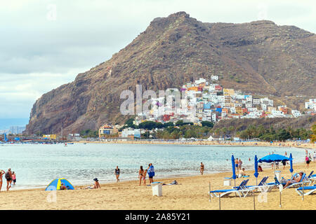 Teneriffa, Spanien - Oktober 13, 2019: Urlauber zum Sonnenbaden am Sandstrand von malerischen Strand von Playa de Las Teresitas, Kanarische Inseln, Spanien Stockfoto