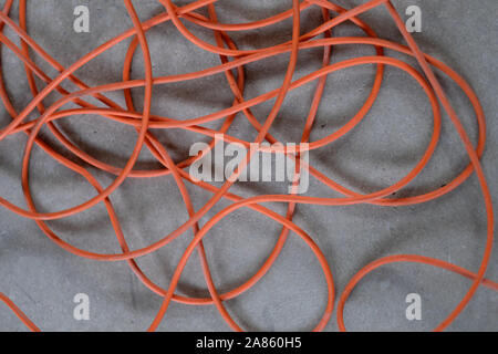 Eine lange verwirrt elektrische Kabel auf grauem Beton Boden Stockfoto