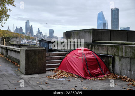 Zelt von Obdachlosen im öffentlichen Raum in London von Thames River auf Herbst Tag grau, mit Skyline im Hintergrund Stockfoto