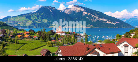 Antenne Panoramablick von Spiez Kirche und Schloss am Ufer des Thunersees im Schweizer Kanton Bern bei Sonnenuntergang, Spiez, Schweiz. Stockfoto