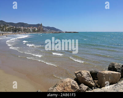 Strand und Meer in Sitges mit Blick auf die Kirche Stockfoto