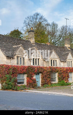 Parthenocissus Tricuspidata. Boston Ivy/Japanische Kriechgang im Herbst auf einem Cotswold Cottage in Burford, Cotswolds, Oxfordshire, England Stockfoto