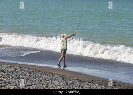 Frau im Prozess der Surf casting am Strand Stockfoto