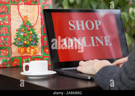 Mädchen sitzt an einem Laptop und macht Einkäufe über das Internet zu Weihnachten. Schnelle und einfache Trading Konzept Stockfoto