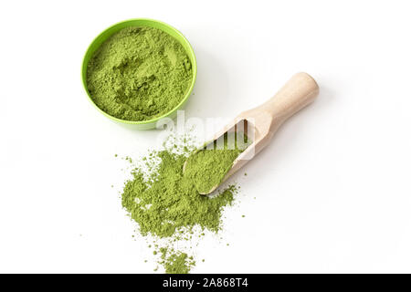 Löffel aus Holz mit pulverisiertem Matcha grüner Tee in der Schüssel, auf weißem Hintergrund. Stockfoto