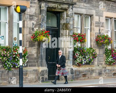 Schottischer Mann mit Kilt, der auf der Straße an einem Belisha-Leuchtfeuer vorbeiläuft, Tay Street, Perth City, Schottland, Großbritannien Stockfoto