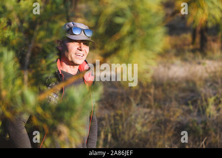 Portrait von müde Touristen obwohl Tannenzweigen. Nadelwald in den Hintergrund. Schöne ältere Menschen wandern. Stockfoto