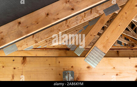 Dachbinder mit einer Membran auf ein freistehendes Haus im Bau, Blick von Innen, sichtbare Dach und Dachstuhl Platten. Stockfoto