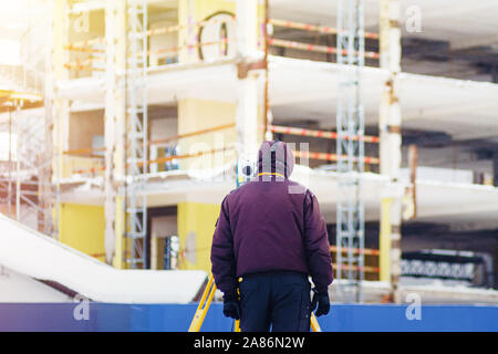 Vermessungsingenieur verwendet eine total Station auf einer Baustelle. Geodätische Arbeiten. Hochbau Stockfoto