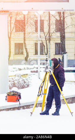 Vermessungsingenieur verwendet eine total Station auf einer Baustelle. Geodätische Arbeiten. Hochbau Stockfoto