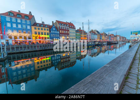 Kopenhagen, Dänemark - 22. MAI 2017: Blick auf die Boote und Gebäude entlang der Nyhavn in den frühen Abend. Die Leute können in Restaurants und reflecti gesehen werden. Stockfoto