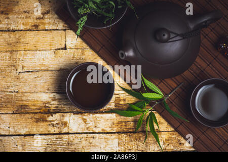 Marihuana Kräutertee und Cannabis Blätter Tischplatte Stockfoto