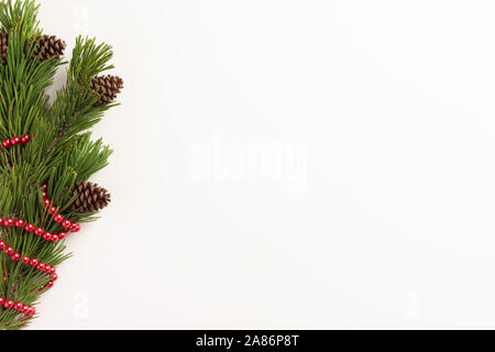 Minimale Weihnachten Konzept. Fichte Zweige mit Zapfen, auf einem weißen Hintergrund. Flach, Ansicht von oben, kopieren. Stockfoto