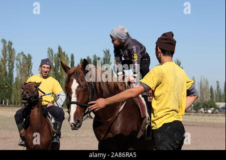 Buzkashi Sportler mit einem jungen Boy in Kirgisistan Stockfoto