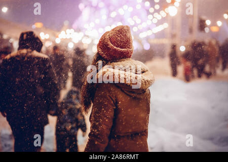 Mädchen gehen durch Weihnachtsmarkt in der Stadt bei Nacht Stockfoto