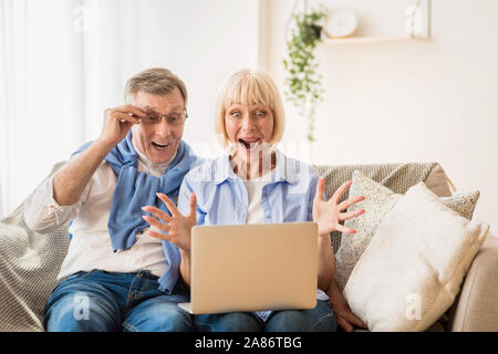 Gewinnen Lotterie. Überrascht reifes Paar gewinnen online Auktion bieten, Stockfoto