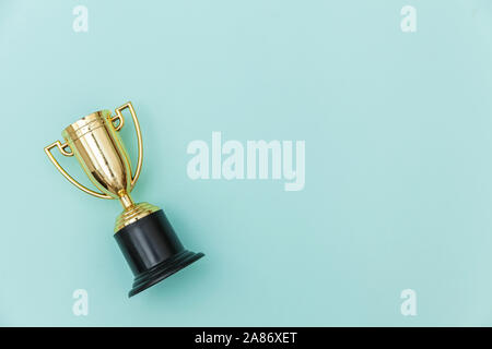 Einfach flach design Sieger oder Meister gold Trophäe Cup auf Blau Pastell bunten Hintergrund isoliert. Sieg den ersten Platz des Wettbewerbs. Sieg oder Erfolg Konzept. Ansicht von oben kopieren Raum Stockfoto