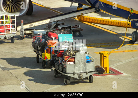 Flughafen NEAPEL, ITALIEN - AUGUST 2019: Koffer, Koffer-LKW gestapelt warten in ein Flugzeug am Flughafen Neapel geladen werden. Stockfoto