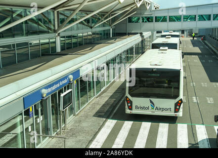 BRISTOL, England - AUGUST 2019: Flughafen Transfer Bus vor dem Eingang für internationale Ankünfte am Flughafen Bristol geparkt. Stockfoto