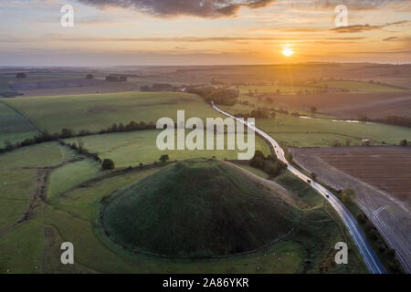 Silbury Hill, Nr Avebury, Wiltshire, UK. 4. November 2019. Drone Bild der Sonnenaufgang über der Jungsteinzeit Damm der Silbury Hill in Wiltshire. Stockfoto