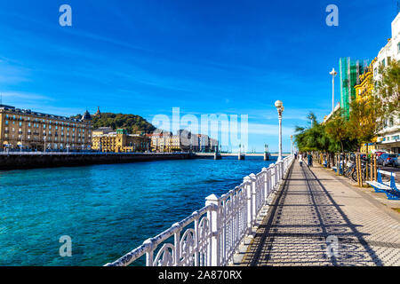 Pedastrian Promenade am Urumea Fluss mit Blick auf die Altstadt, La Zurriola Brücke und Urgul Hill, Ramón María Lili Pasealekua, San Sebastian, Spanien Stockfoto