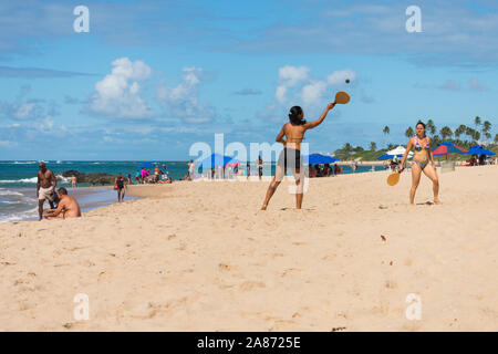 Salvador, Brasilien - ca. September 2019: Zwei Frauen frescobol spielen (eine Art Beach Tennis) am Itapua Beach Stockfoto